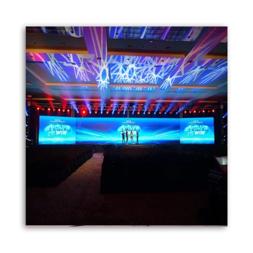 Event stage featuring large LED screens and colorful lighting effects in a conference hall.