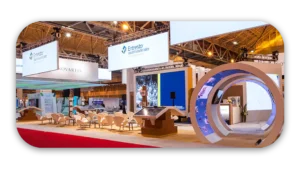 A trade show exhibition booth featuring displays and seating areas with branding signage.