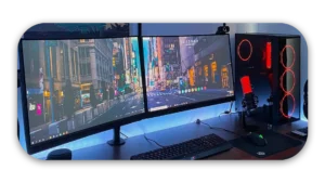 Dual monitors displaying a cityscape background with a keyboard and microphone on a desk.