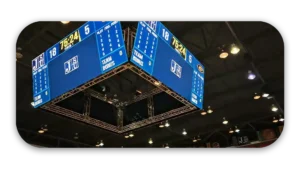 Digital scoreboard showing game statistics and team scores in a sports arena.