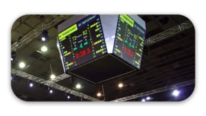 Digital scoreboard showing scores and timer in a sports arena during a game.