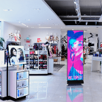 Colorful digital display featuring a model in a retail store environment.